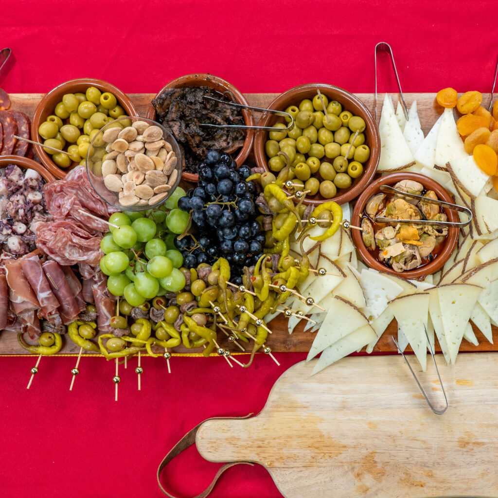 Spanish charcuterie board with olives, Manchego, cured meats, grapes, almonds and gildas