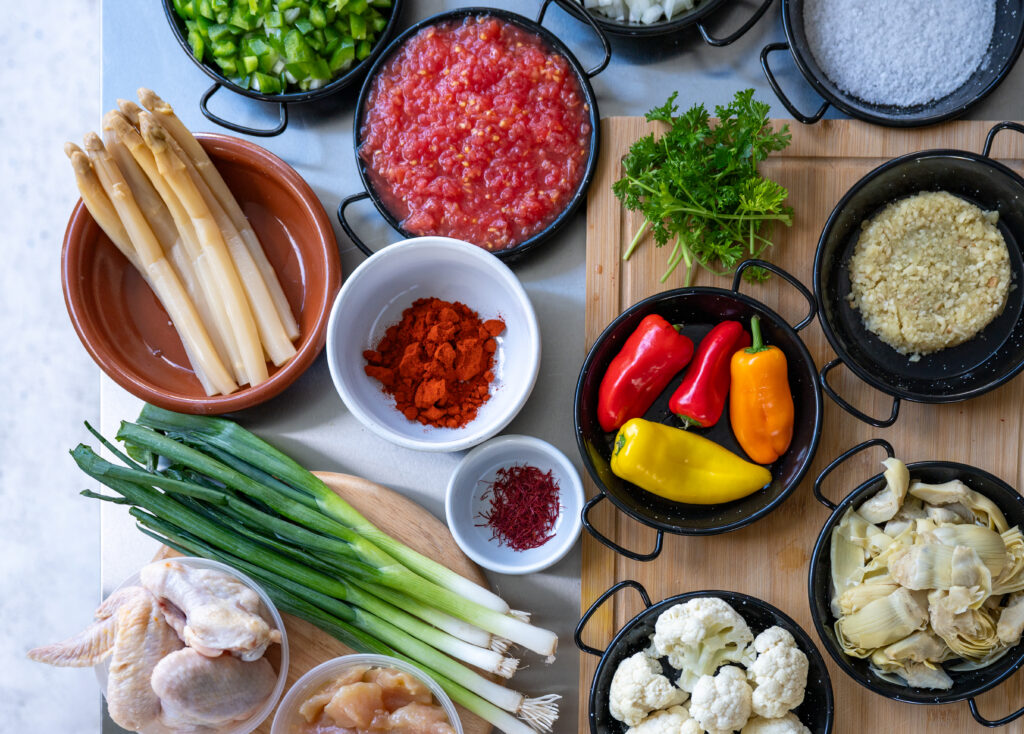 Fresh paella ingredients: white asparagus, tomato, peppers, saffron and paprika