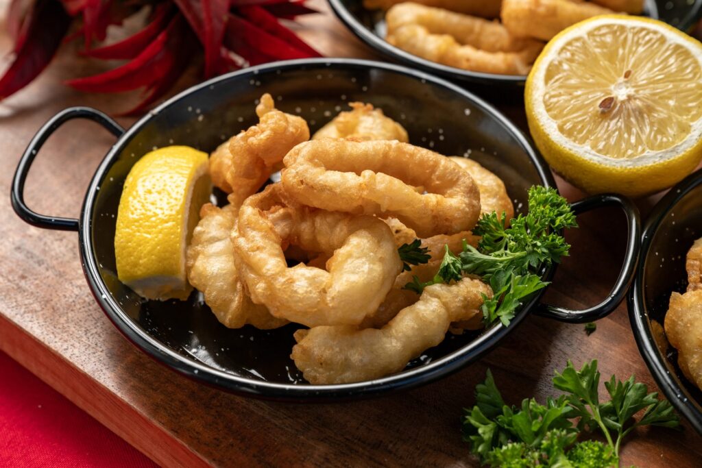 Golden calamares a la romana with a lemon wedge