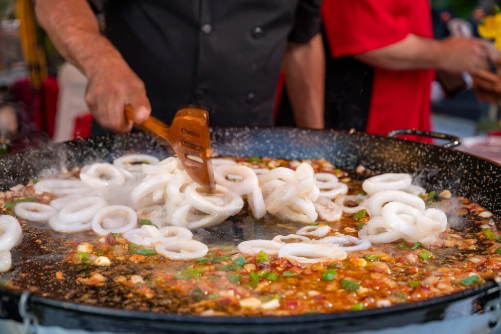 Calamari cooking in sofrito in the paella pan