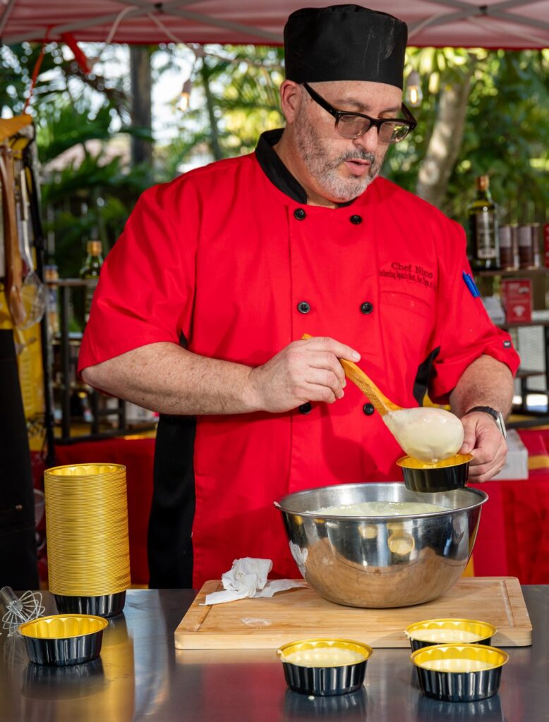 Chef Nino filling individual cups of crema catalana at a backyard event