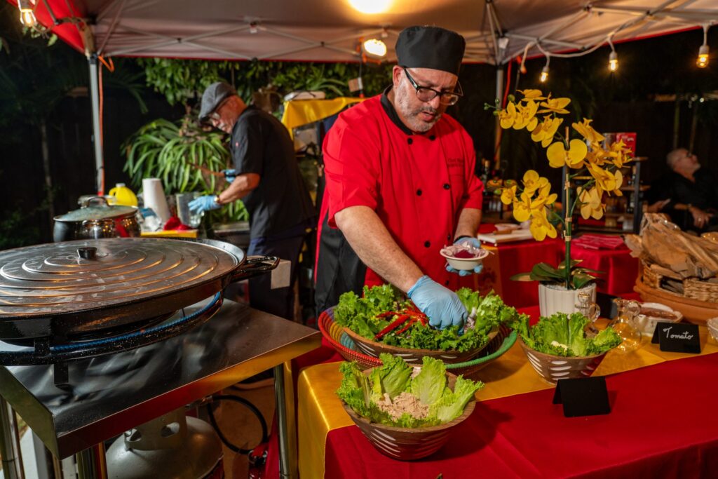 Chef Nino plating the salad station under the pavilion
