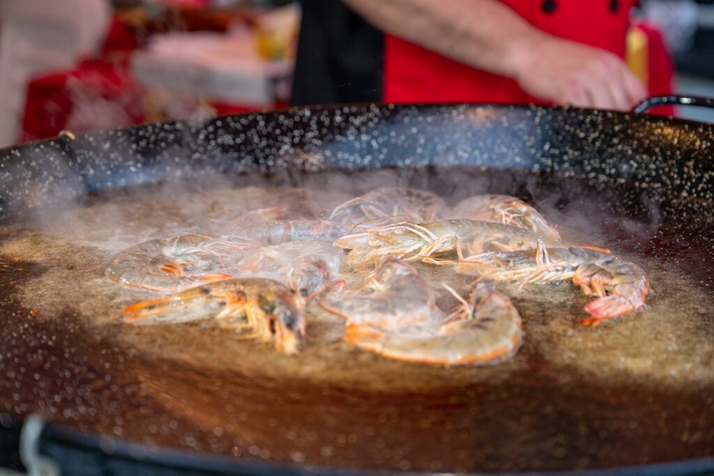Shrimp searing in olive oil in the paella pan